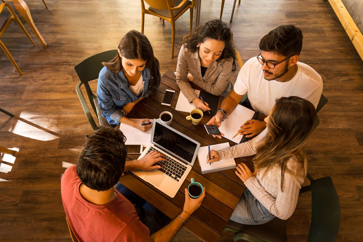 zur Vergrößerungsansicht des Bildes: A group of students sits together at a table and learns