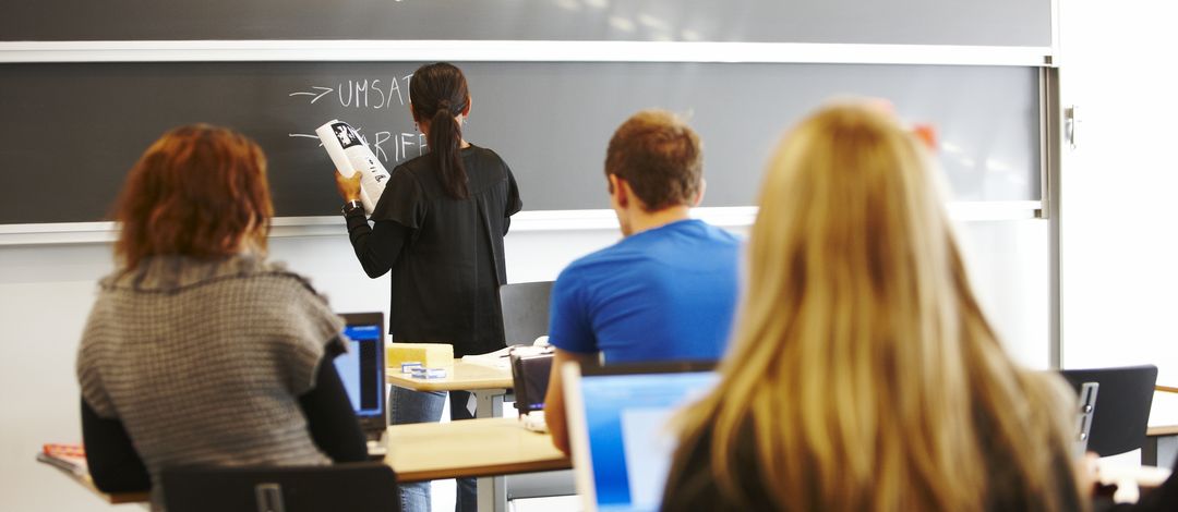 Lehrerin schreibt an die Tafel