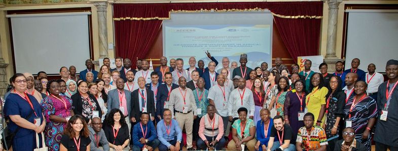 [Translate to English:] Gruppenfoto der Teilnehmenden der ACCESS International Employability Research Conference in einem festlichen Veranstaltungsraum. Die Personen sind vor einer Projektionsleinwand mit Konferenz-Logo versammelt und tragen Namensschilder. Mitwirkende der ACCESS International Employability Research Conference in Tunesien, Foto: ACCESS / SEPT Universität Leipzig