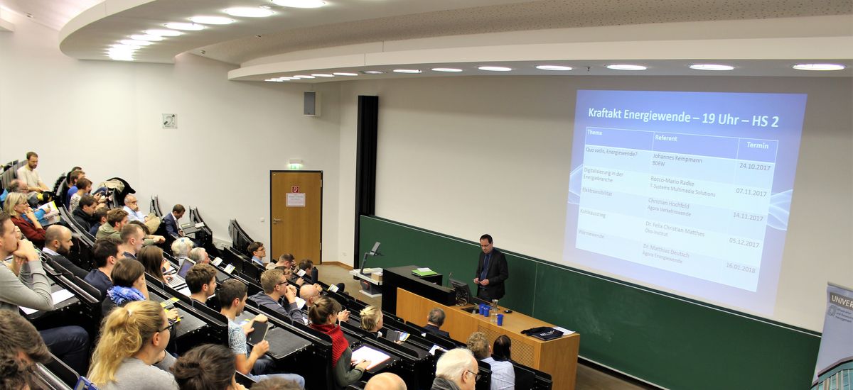 Foto von Prof. Bruckner vor dem Publikum, während er die Veranstaltung eröffnet.