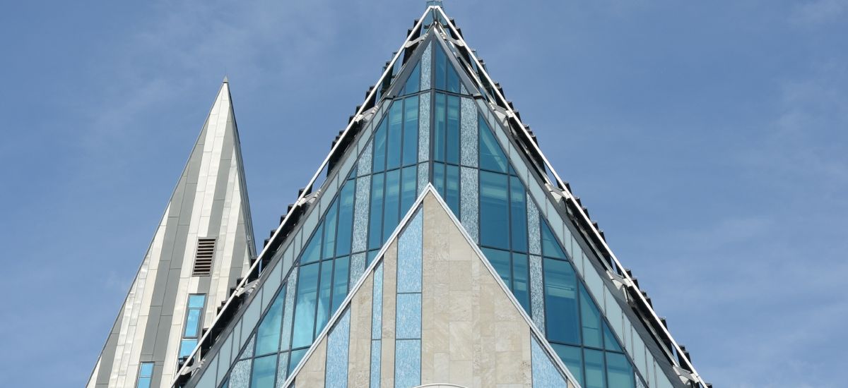 Foto: Spitze der Glasfassade des Paulinums bei blauem Himmel