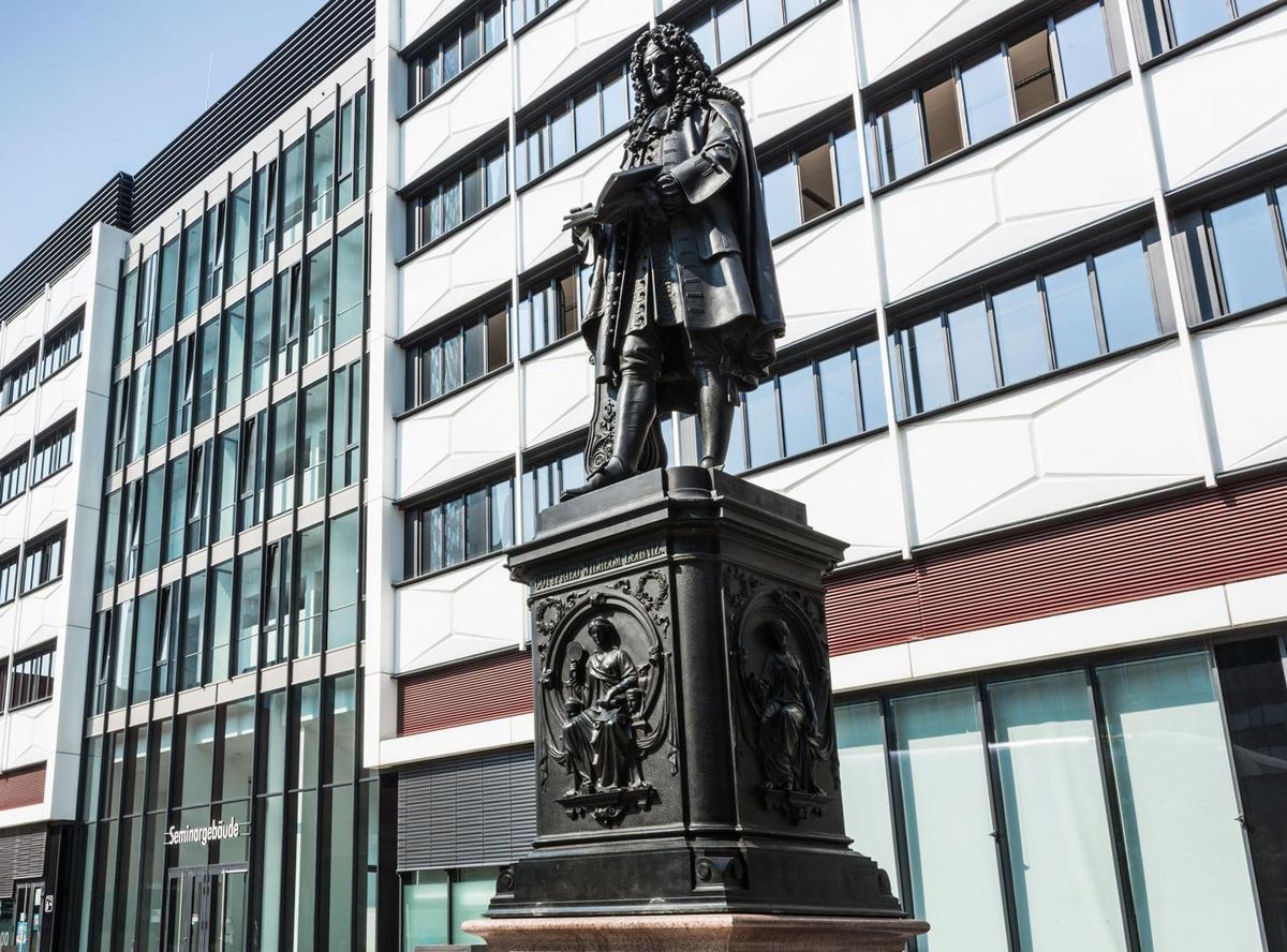 enlarge the image: Foto: eine junge Frau läuft auf dem Uniinnenhof am Seminargebäude vorbei