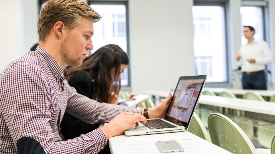 zur Vergrößerungsansicht des Bildes: Eine Student im Masterstudiengang Volkswirtschaftslehre macht sich im Seminarraum am Notebook Notizen.