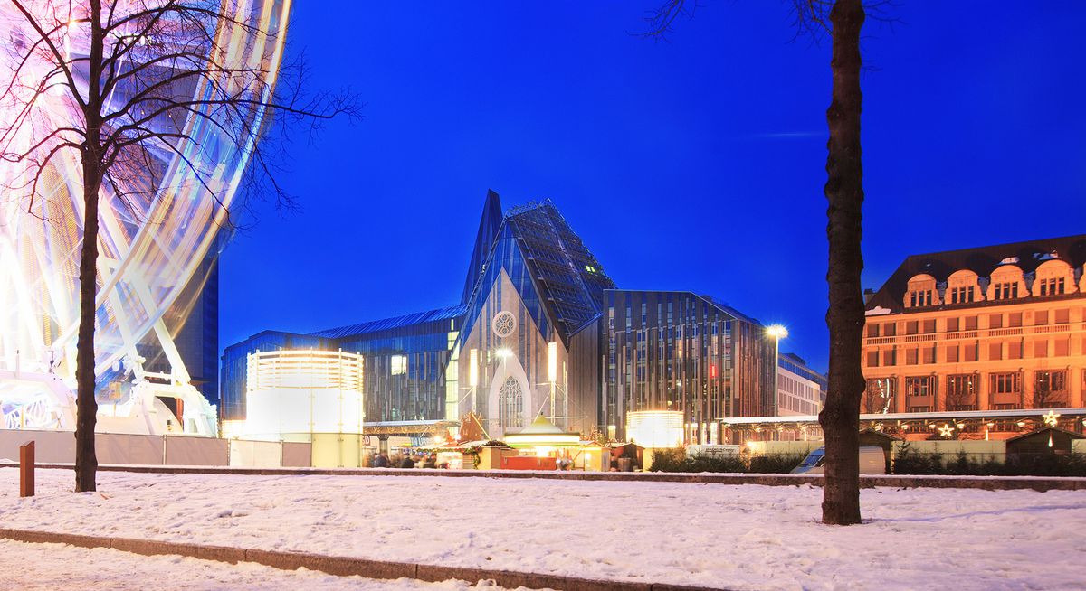 zur Vergrößerungsansicht des Bildes: Foto: Seitliche Ansicht auf das Hauptgebäude der Universität am Campus Augustusplatz in weihnachtlicher Atmosphäre und Lichterbogen vom Riesenrad.