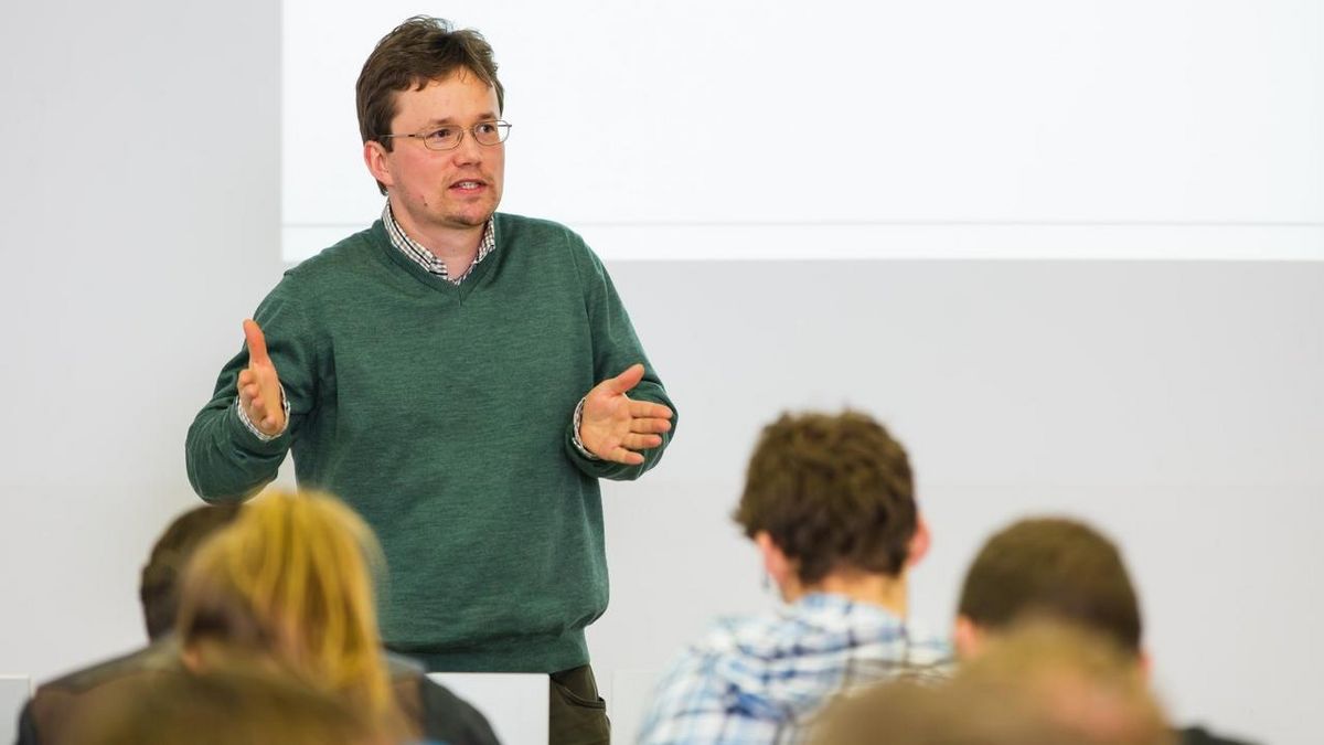 zur Vergrößerungsansicht des Bildes: Ein Dozent im Masterstudiengang Wirtschaftspädagogik erläutert die Studieninhalte..