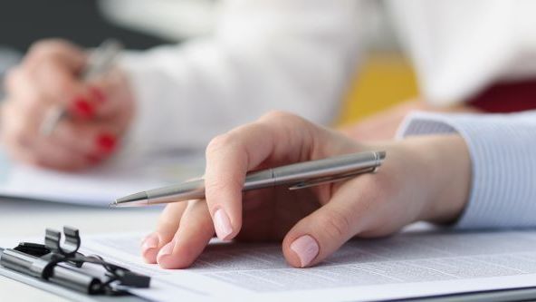 Hand mit Stift auf Clipboard, Foto: Colourbox